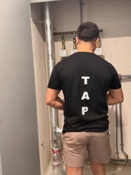 Plumber running pipework and valves during a bathroom rough-in